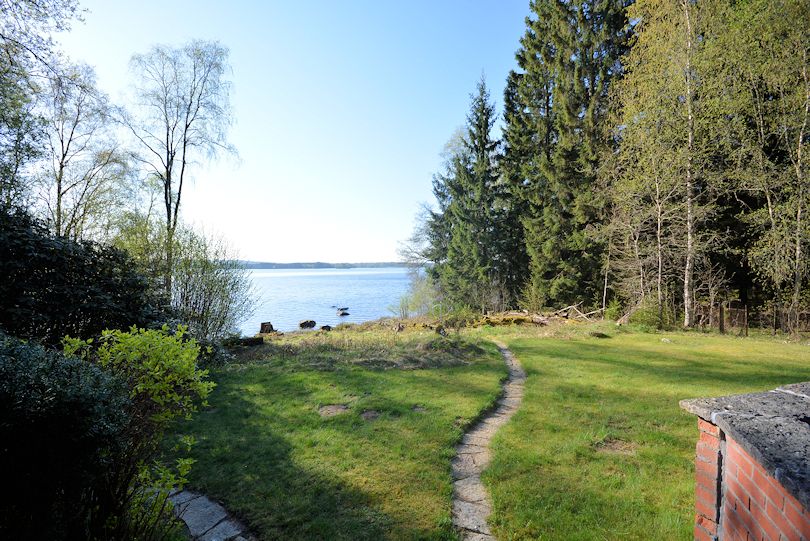 Abschwung zum See. Das Wohnhaus liegt maximal 30 m vom Ufer entfernt Galeriebild Herrestadsjön - Schwedenvilla direkt am See mit eigenem kleinen Sandstrand und herrlichem Wasserblick!